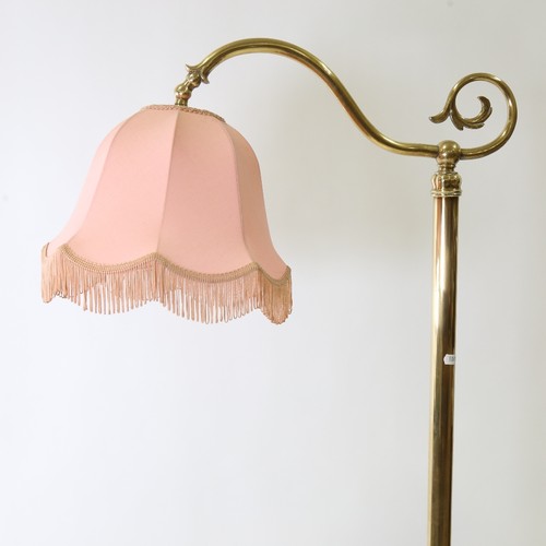 438 - A late 19th early 20th century brass standard lamp with pink shade, height 168cm