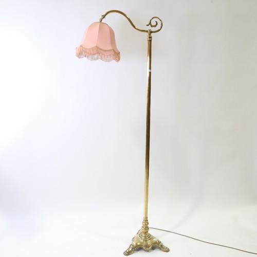 438 - A late 19th early 20th century brass standard lamp with pink shade, height 168cm