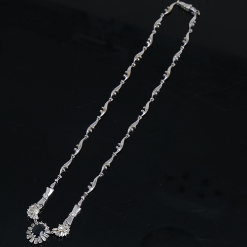 1253 - A modern 18ct white gold sapphire and diamond cluster necklace, set with 2.85ct oval-cut sapphire, s... 