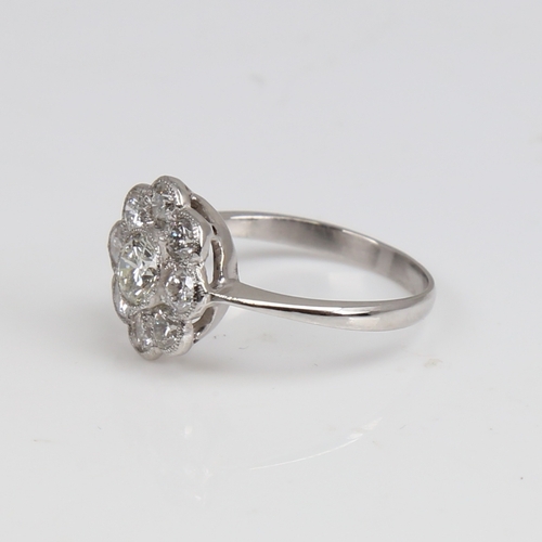 1292 - An unmarked white gold diamond cluster flowerhead ring, set with modern round brilliant-cut diamonds... 