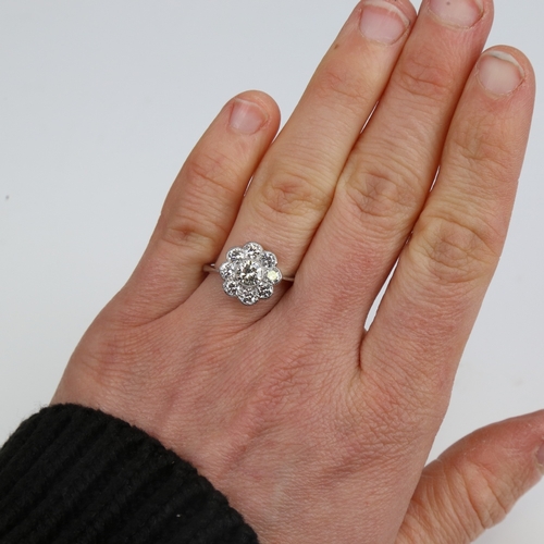 1292 - An unmarked white gold diamond cluster flowerhead ring, set with modern round brilliant-cut diamonds... 