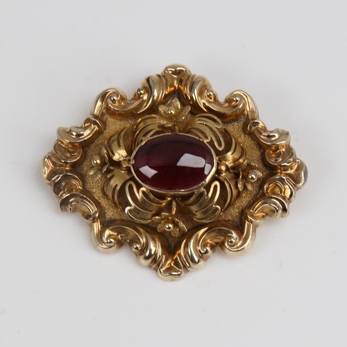 1293 - A Victorian unmarked gold cabochon garnet brooch, relief foliate border with textured ground and flo... 