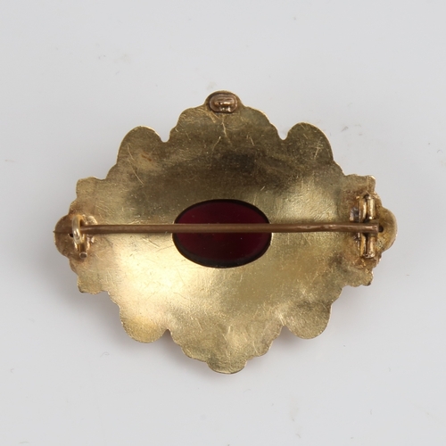 1293 - A Victorian unmarked gold cabochon garnet brooch, relief foliate border with textured ground and flo... 