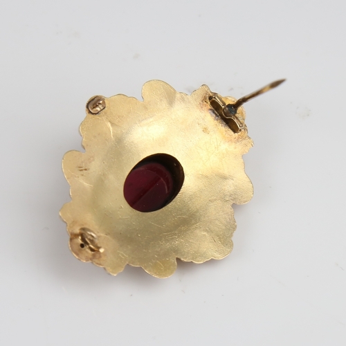 1293 - A Victorian unmarked gold cabochon garnet brooch, relief foliate border with textured ground and flo... 