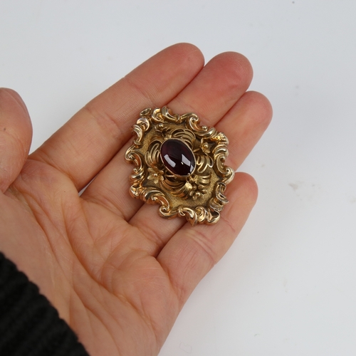 1293 - A Victorian unmarked gold cabochon garnet brooch, relief foliate border with textured ground and flo... 