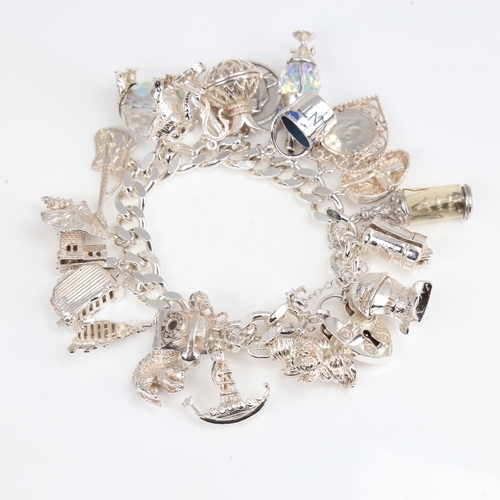 1391 - A late 20th century heavy sterling silver flat curb link charm bracelet, with heart padlock and fill... 