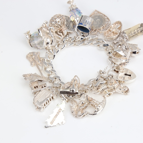 1391 - A late 20th century heavy sterling silver flat curb link charm bracelet, with heart padlock and fill... 