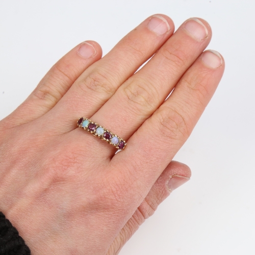 1397 - A late 20th century 9ct gold 7-stone opal and garnet half hoop ring, set with round cabochon opals a... 