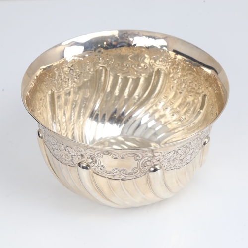 1408 - An Edwardian silver bowl, plain circular half fluted form with relief embossed floral decoration, by... 