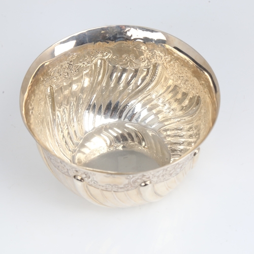 1408 - An Edwardian silver bowl, plain circular half fluted form with relief embossed floral decoration, by... 