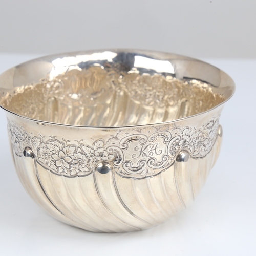 1408 - An Edwardian silver bowl, plain circular half fluted form with relief embossed floral decoration, by... 