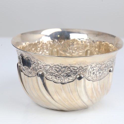 1408 - An Edwardian silver bowl, plain circular half fluted form with relief embossed floral decoration, by... 