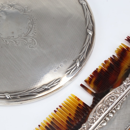 1410 - A silver-backed dressing table hand mirror, and 2 silver-mounted combs, mirror length 28cm (3)