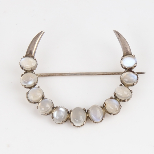 1422 - An Arts and Crafts unmarked silver and cabochon moonstone crescent moon brooch, largest moonstone le... 