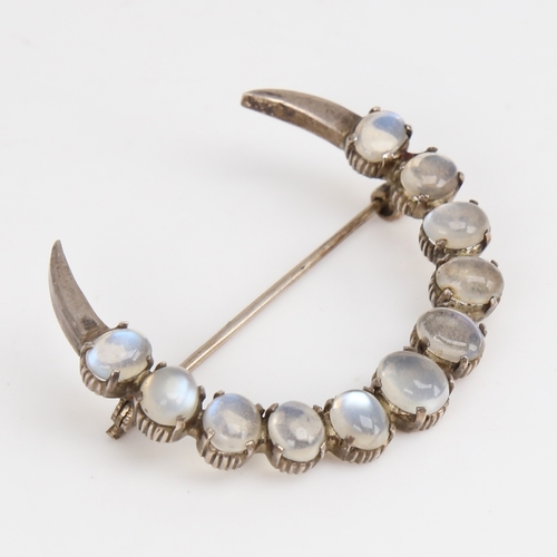 1422 - An Arts and Crafts unmarked silver and cabochon moonstone crescent moon brooch, largest moonstone le... 