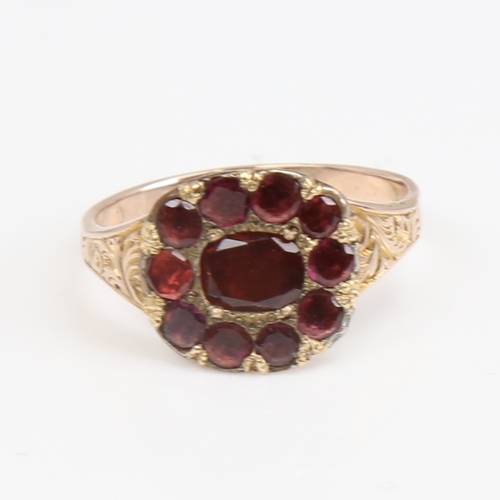 1425 - A Georgian unmarked gold flat-top garnet ring, foliate engraved shoulders with closed backs, setting... 