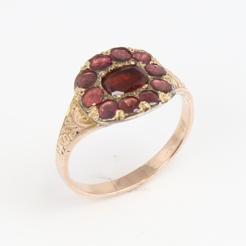 1425 - A Georgian unmarked gold flat-top garnet ring, foliate engraved shoulders with closed backs, setting... 