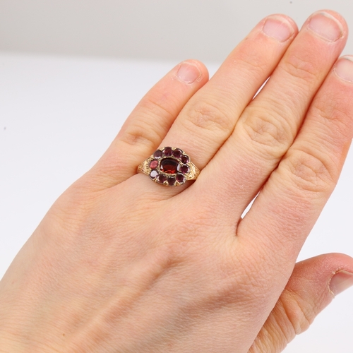 1425 - A Georgian unmarked gold flat-top garnet ring, foliate engraved shoulders with closed backs, setting... 