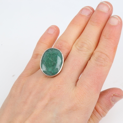 1427 - A modern sterling silver emerald ring, set with large oval mixed-cut emerald, setting height 24.3mm,... 