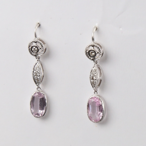 1429 - A pair of unmarked white metal pink topaz and diamond drop earrings, set with oval mixed-cut topaz a... 