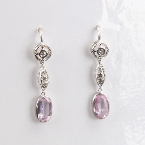 1429 - A pair of unmarked white metal pink topaz and diamond drop earrings, set with oval mixed-cut topaz a... 