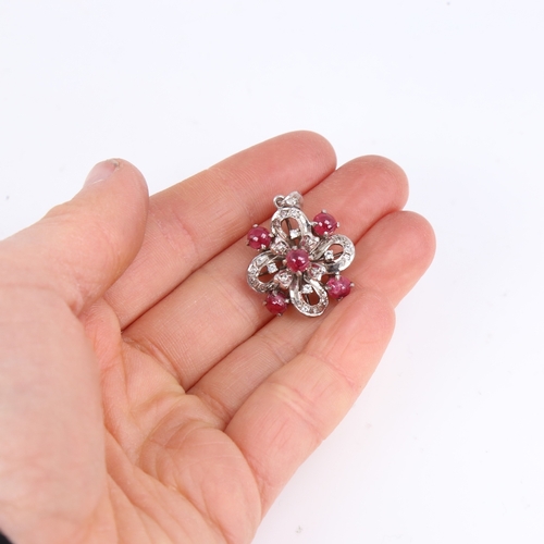 1451 - A Vintage unmarked white metal ruby and diamond flowerhead pendant, set with cabochon ruby and eight... 