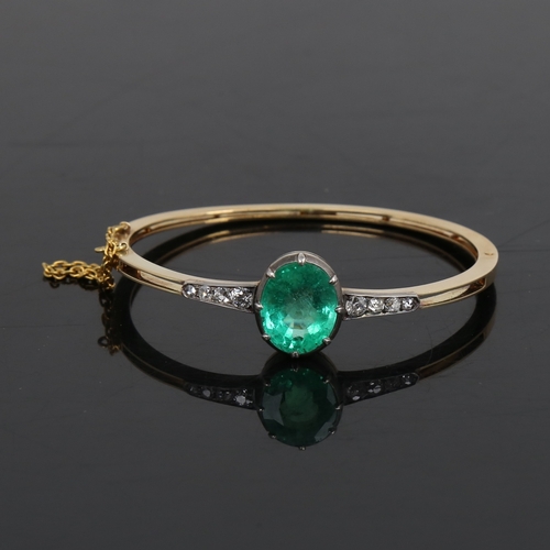 1455 - An Antique unmarked gold emerald and diamond hinged bracelet/bangle, set with 7.52ct oval mixed-cut ... 