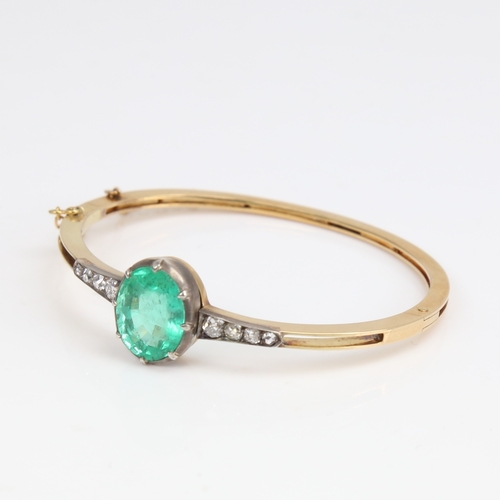 1455 - An Antique unmarked gold emerald and diamond hinged bracelet/bangle, set with 7.52ct oval mixed-cut ... 