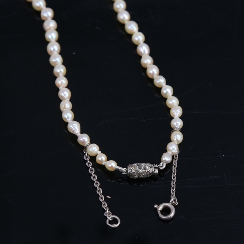 1460 - A single-strand graduated pearl necklace, with unmarked white metal rose-cut diamond set clasp, pear... 