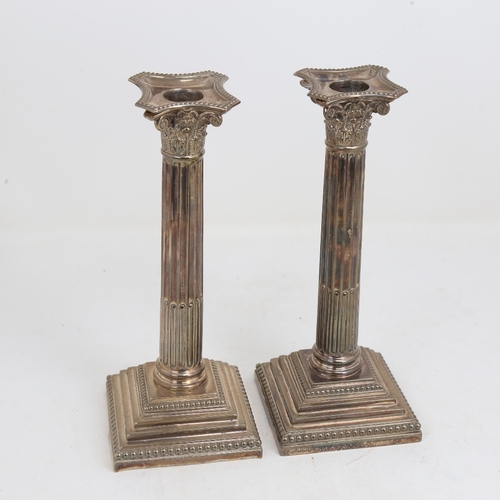 1523 - A pair of George V silver Corinthian column table candlesticks, stepped bases with removeable sconce... 