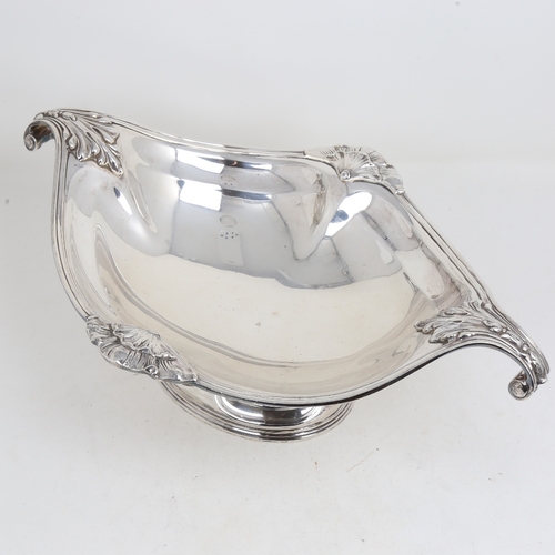 1525 - A large George V silver 2-handled table centre fruit bowl, oval form with cast scrolled acanthus lea... 