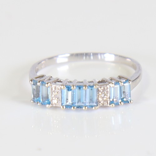 81 - A modern 9ct white gold blue topaz and diamond half hoop ring, set with baguette cut topaz and eight... 