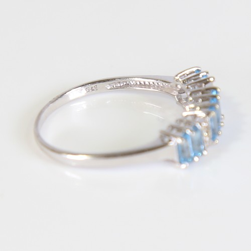 81 - A modern 9ct white gold blue topaz and diamond half hoop ring, set with baguette cut topaz and eight... 