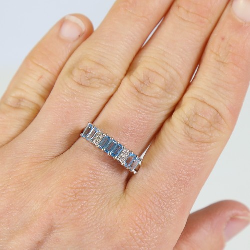 81 - A modern 9ct white gold blue topaz and diamond half hoop ring, set with baguette cut topaz and eight... 