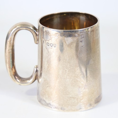 86 - A Victorian silver half pint tankard, tapered cylindrical form with C-shaped handle and gilt interio... 