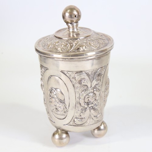 93 - A German silver beaker and cover, Hanau, relief embossed figural and foliate decoration on three bun... 