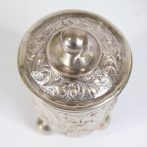 93 - A German silver beaker and cover, Hanau, relief embossed figural and foliate decoration on three bun... 