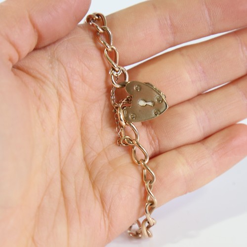 97 - A mid-20th century 15ct rose gold curb link bracelet, with 9ct heart padlock locket clasp, hallmarks... 