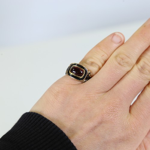 101 - A Georgian 18ct gold garnet and black enamel mourning ring, set with oval cabochon garnet with foil ... 