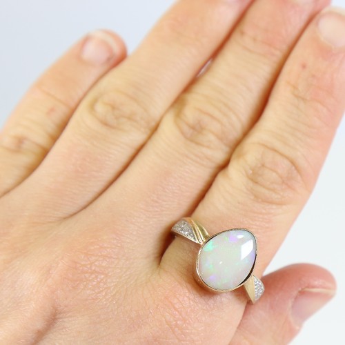 106 - A modern 9ct gold opal and diamond dress ring, set with pear cabochon opal and eight cut diamond sho... 