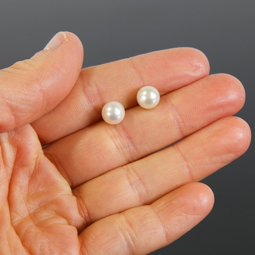 107 - A pair of handmade 14ct gold Japanese whole pearl earrings, plain settings with stud fittings, pearl... 