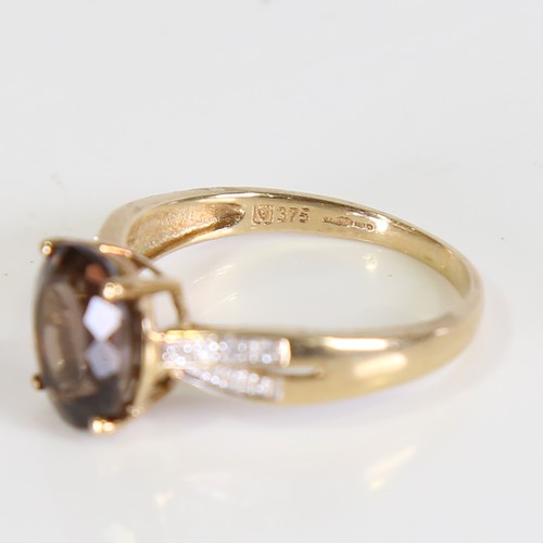 113 - A modern 9ct gold smoky quartz and diamond dress ring, set with oval mixed cut quartz and eight cut ... 