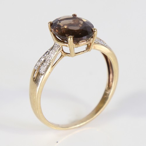 113 - A modern 9ct gold smoky quartz and diamond dress ring, set with oval mixed cut quartz and eight cut ... 