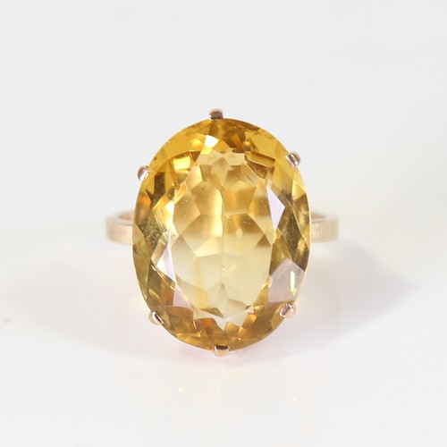 129 - A large late 20th century citrine dress ring, unmarked gold set with large oval mixed cut citrine, s... 