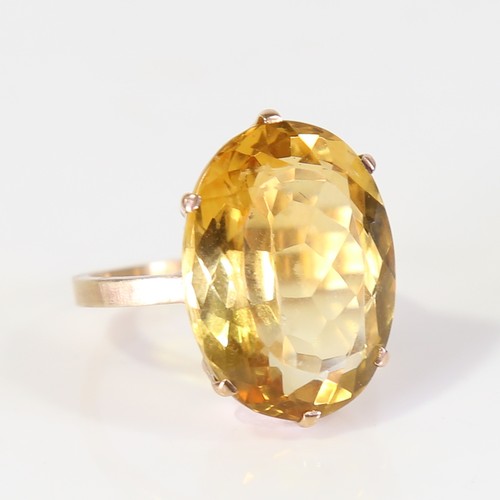 129 - A large late 20th century citrine dress ring, unmarked gold set with large oval mixed cut citrine, s... 