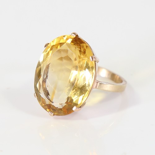 129 - A large late 20th century citrine dress ring, unmarked gold set with large oval mixed cut citrine, s... 