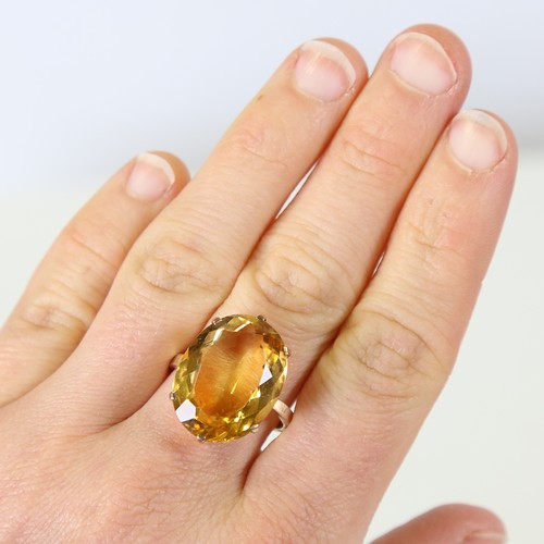 129 - A large late 20th century citrine dress ring, unmarked gold set with large oval mixed cut citrine, s... 