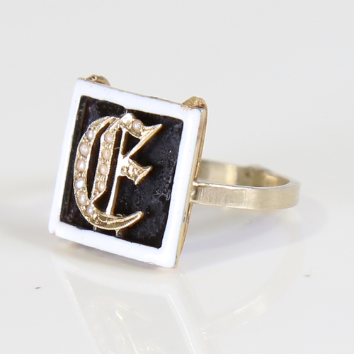 105 - A 19th century Initial E ring, unmarked yellow metal settings with onyx panel, white enamel border a... 