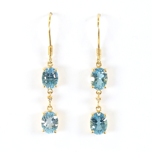 88 - A pair of modern handmade 18ct gold blue topaz and diamond drop earrings, set with oval mixed cut to... 