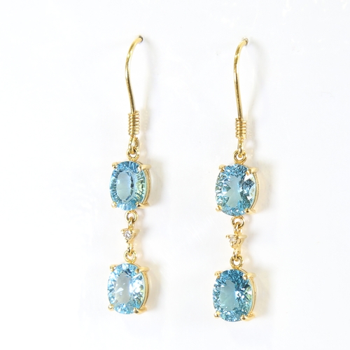 88 - A pair of modern handmade 18ct gold blue topaz and diamond drop earrings, set with oval mixed cut to... 